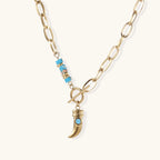 Gold chunky chain necklace with turquoise beaded accent and horn pendant on white background