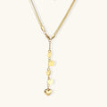 Gold Y-shaped necklace with five graduated heart charms cascading down a herringbone chain on white background