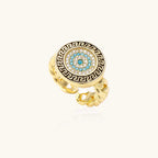 Gold chain ring with Greek key border and turquoise evil eye center on white background