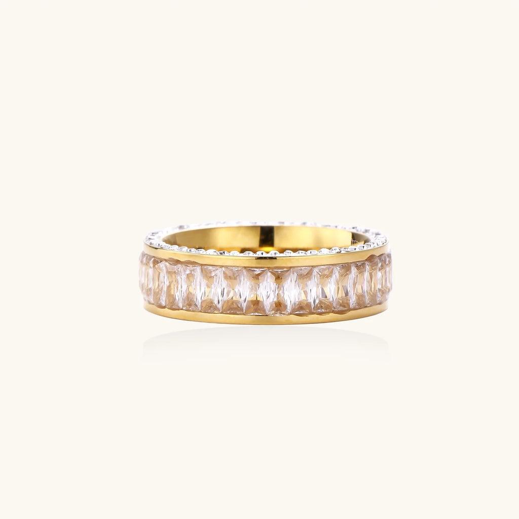 14K gold-plated ring with dual rows of clear baguette and round zirconia stones on cream background.