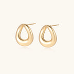 Pair of polished 18K gold-plated stainless steel teardrop earrings with hollow centers on cream background