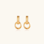 Gold stud earrings with vertical ridged bar connecting to triple interlocking circular rings on white background