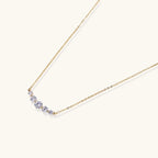 Delicate 14K gold-plated necklace with five graduated zirconia stones arranged in a curved arc on fine chain