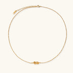 Dainty 18K gold plated necklace with infinity knot pendant on delicate chain against white background