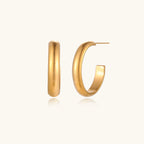 Chunky brushed gold hoop earrings in 14K plated stainless steel on cream background, front and side view.