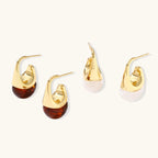 Modern drop earrings with curved gold-plated copper tops and amber resin bottoms creating an organic teardrop silhouette.