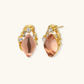 Gold-plated baroque stud earrings with coral-pink liuli stones and cubic zirconia crystals on white background.