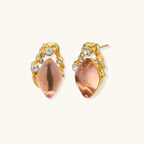 Gold-plated baroque stud earrings with coral-pink liuli stones and cubic zirconia crystals on white background.