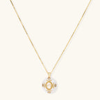 Gold-plated necklace with circular white enamel pendant featuring central zirconia stone and ornate decorative details