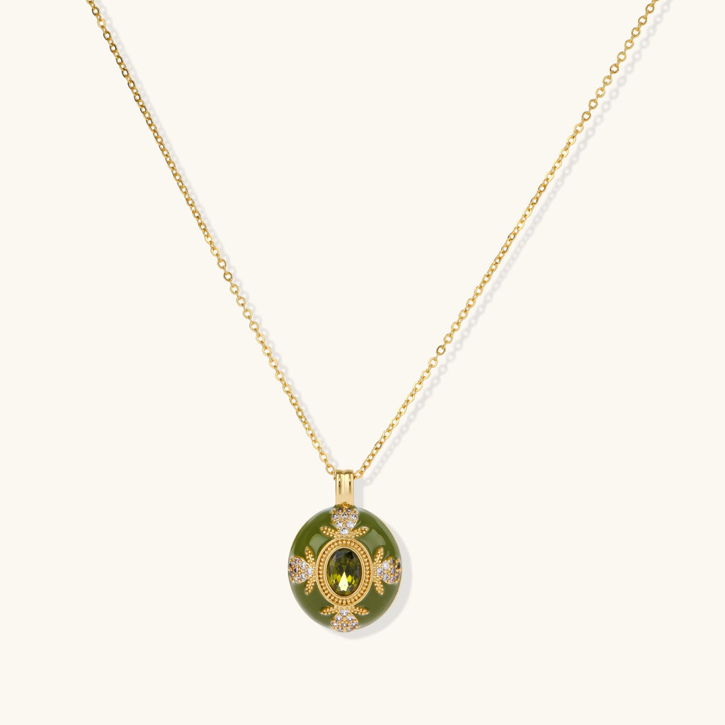 Gold-plated pendant necklace with green enamel background and oval olive cubic zirconia center stone with crystal accents.