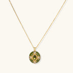 Gold-plated pendant necklace with green enamel background and oval olive cubic zirconia center stone with crystal accents.