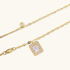 Gold-plated jewelry set with rectangular cubic zirconia stones in pave halo settings on cream background