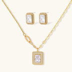 Gold-plated jewelry set with rectangular cubic zirconia stones in pave halo settings on cream background