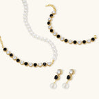 Gold-plated jewelry set with alternating black and clear cubic zirconia stones, featuring necklace, earrings and bracelet