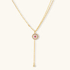 Gold-plated circular medallion necklace set with white enamel base and pink cubic zirconia accent stones