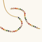 Colorful four-leaf clover jewelry set with rainbow cubic zirconia stones in gold-plated setting on white background