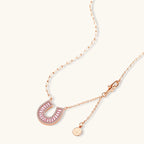 Sparkling horseshoe-shaped jewelry set with AAA cubic zirconia in gold-plated and white gold finishes on cream background.