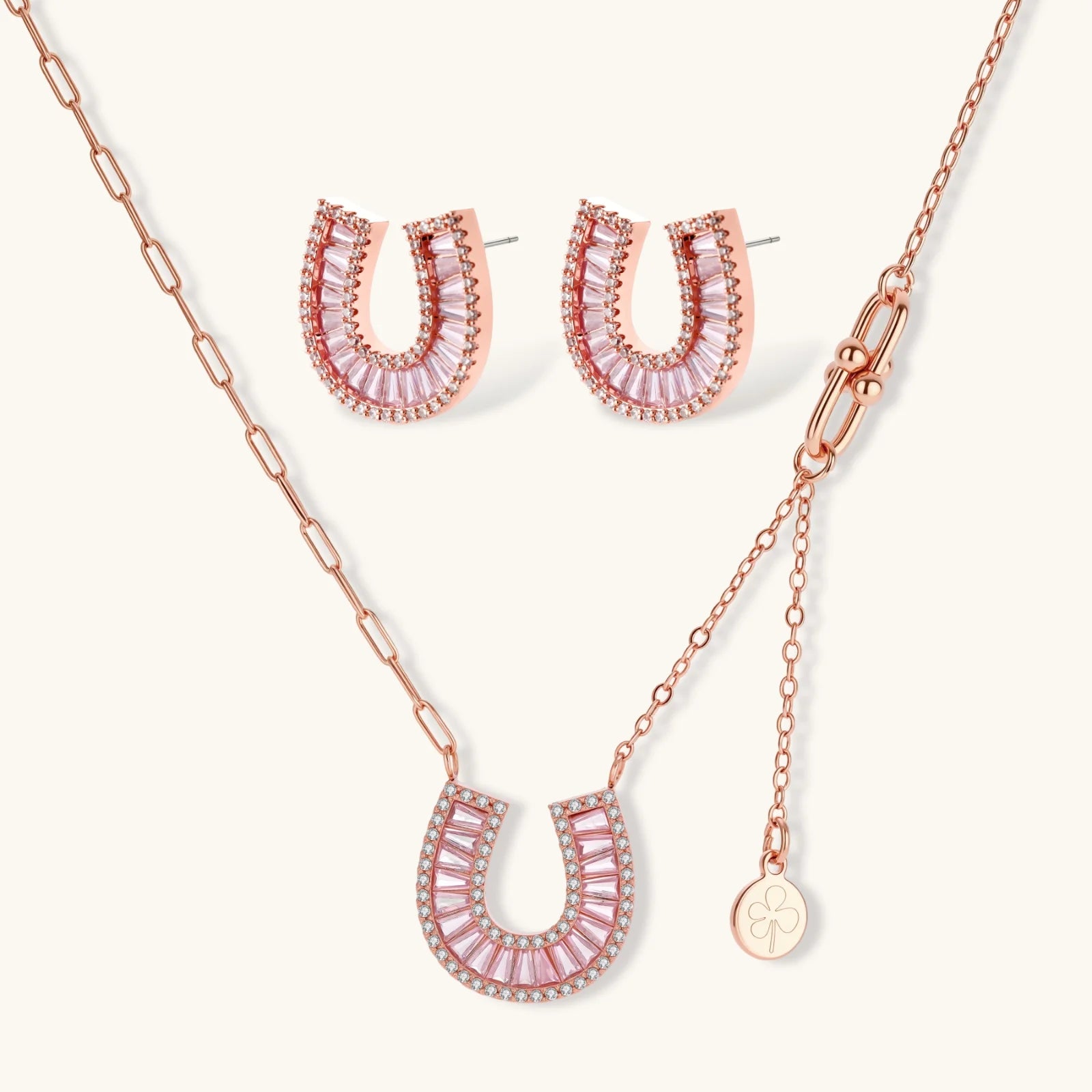 Sparkling horseshoe-shaped jewelry set with AAA cubic zirconia in gold-plated and white gold finishes on cream background.