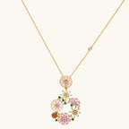 14K gold plated jewelry set with pink and green cubic zirconia flowers arranged in wreath design on cream background