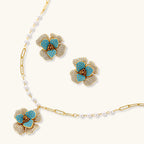 14K gold-plated floral jewelry set with blue cubic zirconia centers and pearl chain details on white background.