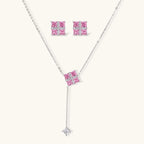 White gold plated jewelry set with pink cubic zirconia stones in geometric cross design, featuring Y-necklace and square stud earrings