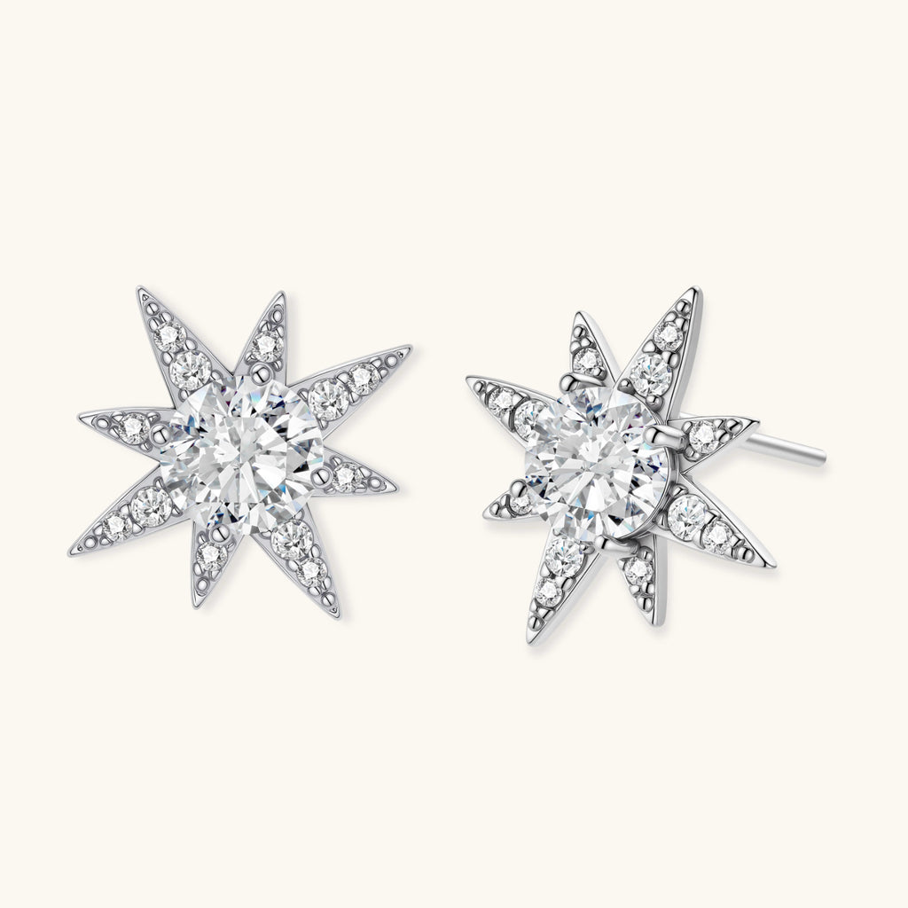 Sterling silver star-shaped stud earrings with brilliant moissanite center stones and pavé details on neutral background.