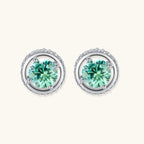 Round green moissanite stud earrings in sterling silver halo settings with brilliant sparkle on white background.