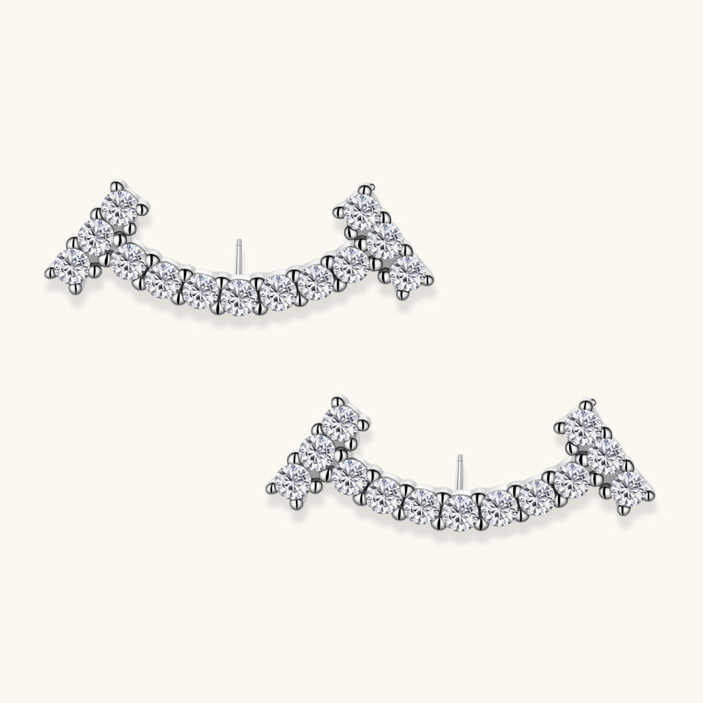 Curved sterling silver ear climbers with moissanite stones arranged in elegant arc shape on white background
