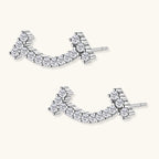 Curved sterling silver ear climbers with moissanite stones arranged in elegant arc shape on white background