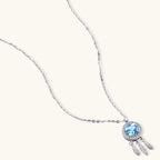 Sterling silver dreamcatcher pendant with blue moissanite center and three feather charms on adjustable chain.