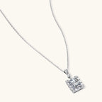 Square moissanite pendant with halo setting on delicate sterling silver chain against white background.