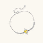 Sterling silver bracelet with yellow moissanite centerpiece in oval setting, crystal chain, and star charm on white background.