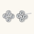 Dainty sterling silver quatrefoil stud earrings with four brilliant moissanite stones and center accent on white background.